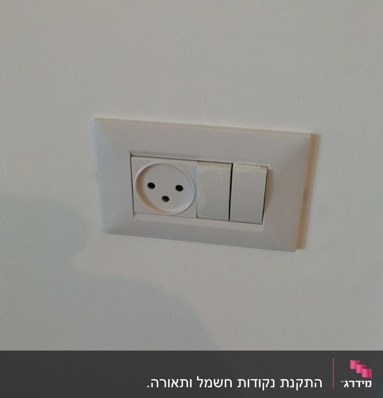 שקע חשמל עם שני מתגים על קיר לבן